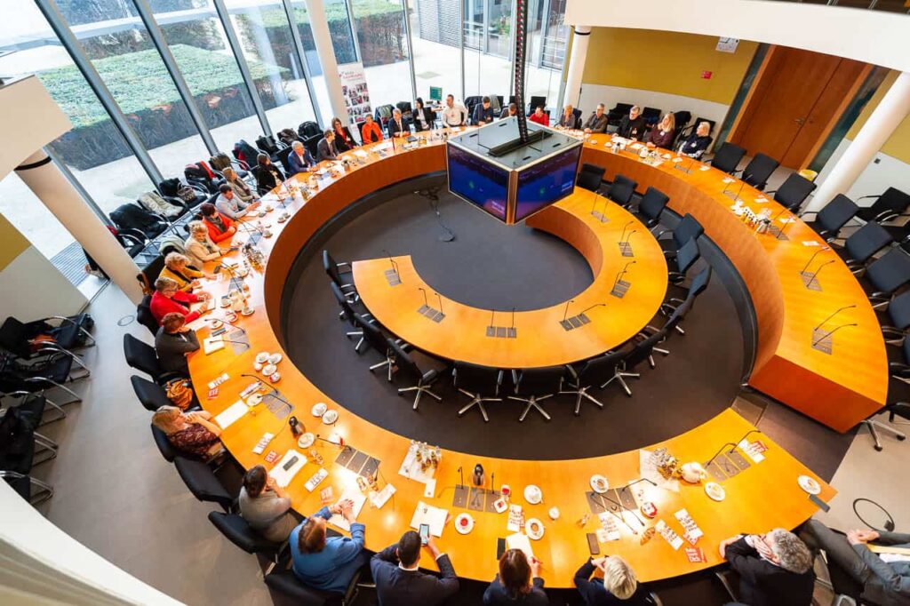Das Bild zeigt einen Blick von oben in den Sitzungssaal wärend der Abschlussveranstaltung der Reha-Zukunftsstaffel im Paul-Löbe-Haus im Bundestag.