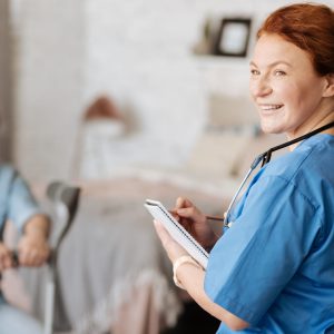 Positive approach to treatment. Enthusiastic clever amazing woman using her journal for writing down patients symptoms while conducting a consolation