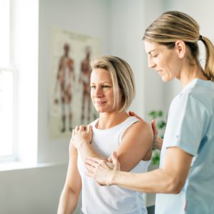 Modern rehabilitation physiotherapy worker with woman client