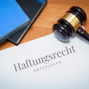 Haftungsrecht. Dokument mit Text/Beschriftung. Schreibtisch mit Büchern und Richterhammer bei einem Anwalt.