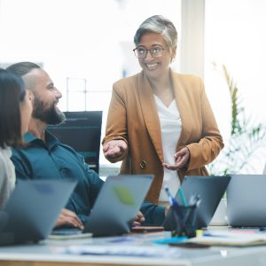 Happy people, laptop and meeting, marketing team and workflow at digital agency, creative group and research. Man, women and diversity, business and work together, senior leader and brand strategy.