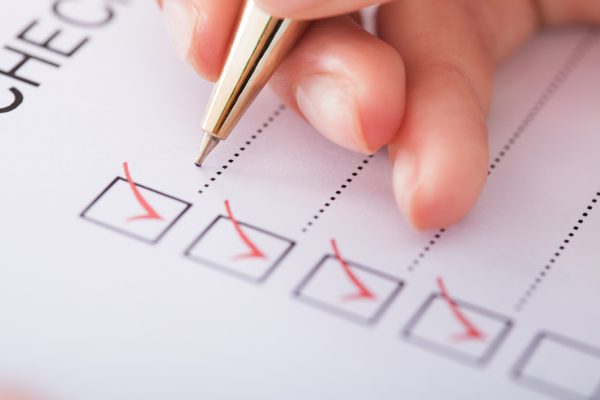 Cropped image of businesswoman writing on checklist